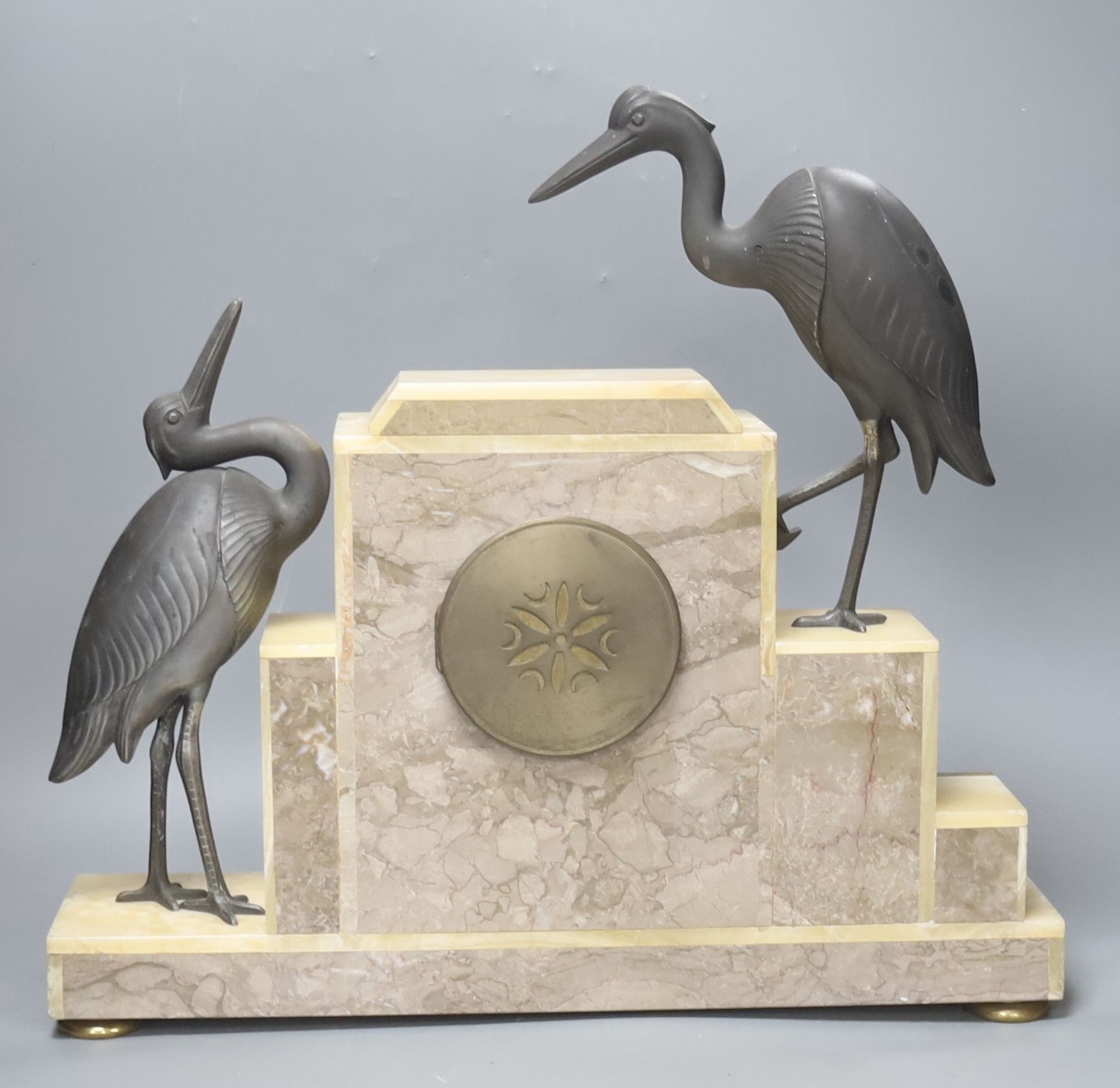 An Art Deco marble clock garniture clock surmounted with two spelter cranes, 42cm